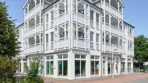 A white building with multiple balconies and large windows, featuring a traditional architectural style. - Ferienwohnung im 3.OG mit Balkon in Sellin (Sellin)