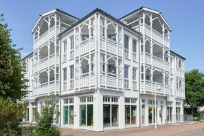 A white building with multiple balconies and large windows, featuring a traditional architectural style. - Ferienwohnung im 3.OG mit Balkon in Sellin (Sellin)