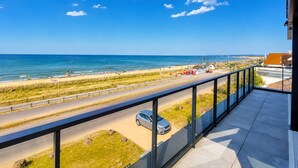 Een balkon met uitzicht op een strand en een weg.
