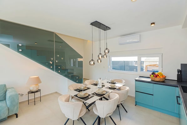 Una cocina moderna con comedor, una escalera y vistas al exterior.