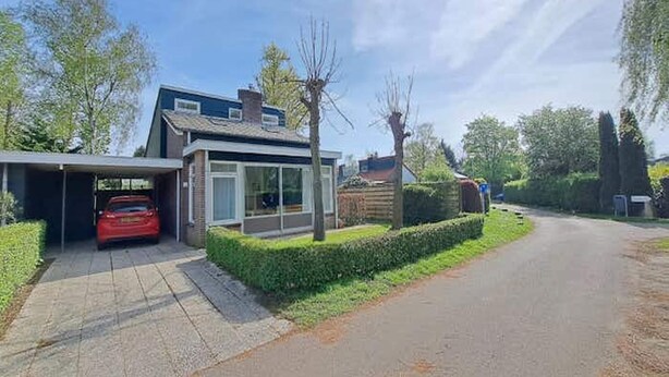 A residential house with a garage, a driveway, and a well-maintained lawn.