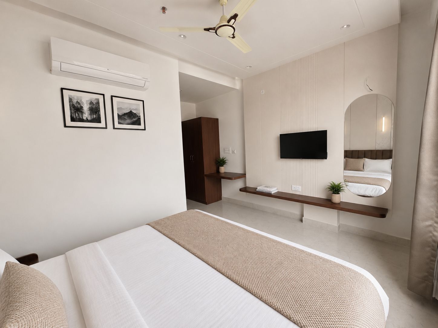 Un dormitorio moderno con cama, televisor, espejo y ventilador de techo.