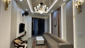 Una sala de estar moderna con un sofá, una mesa de centro, un televisor y una araña.