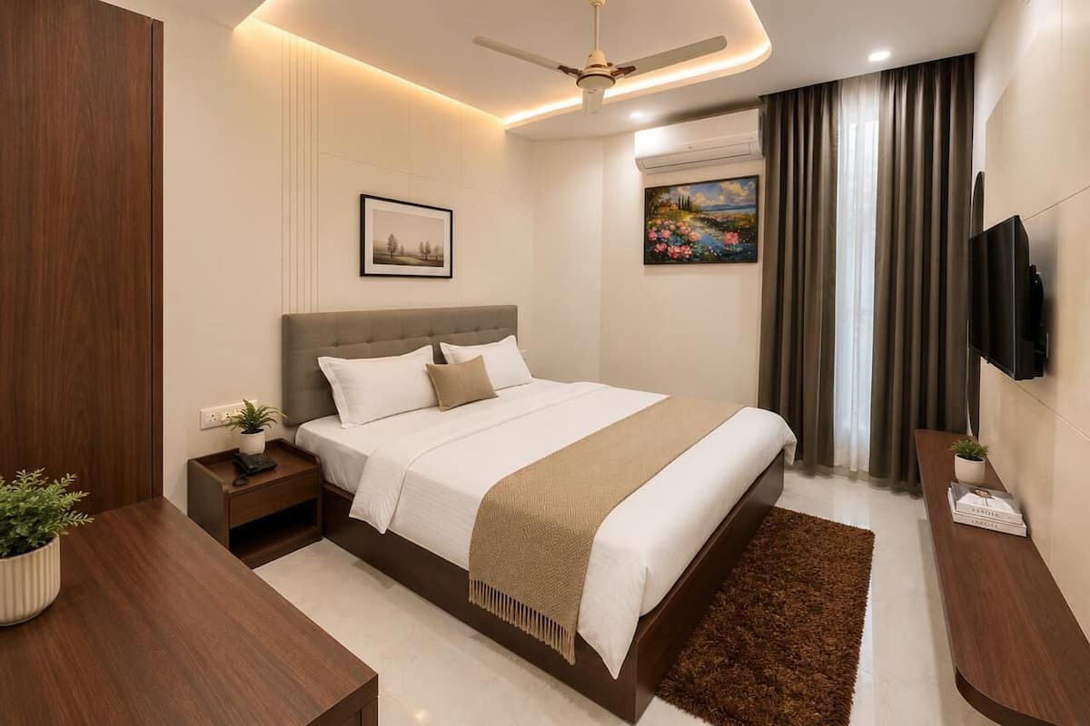 A modern hotel room with a bed, bedside tables, a ceiling fan, a TV, and artwork on the walls.
