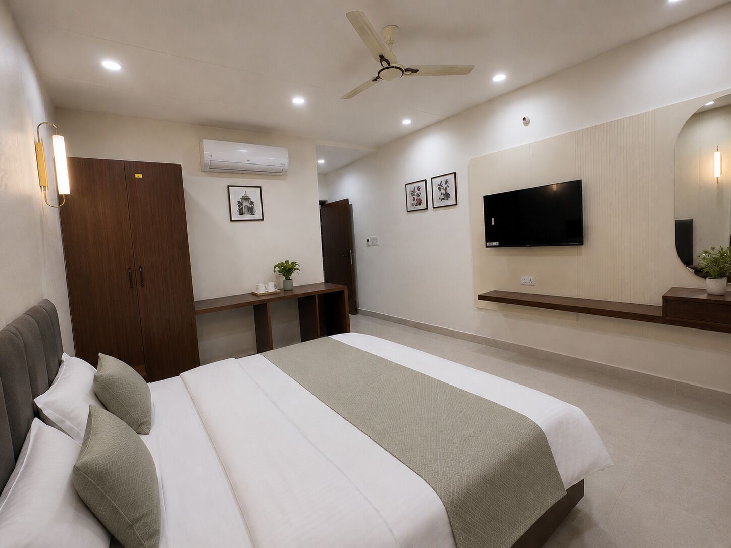 Quarto com cama, televisão, ventoinha no teto, guarda-roupa e secretária.