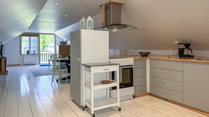 Une cuisine moderne équipée d’un four encastré, d’une machine à café et d’un chariot muni d’une étagère.
