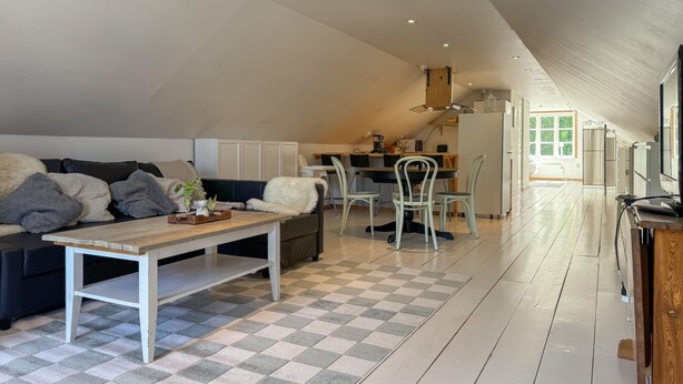 Un loft spacieux avec de hauts plafonds, un coin repas et une cuisine.