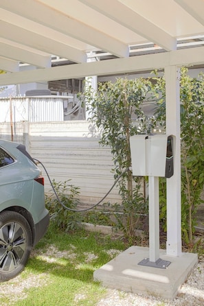 A car charging at an outdoor electric vehicle charging station. - Residence Maratta 54 Orchidea (Terni)
