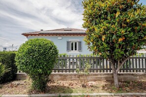 A single-story house with a light blue exterior, a tiled roof, and a white fence in front. - Residence Maratta 54 Orchidea (Terni)