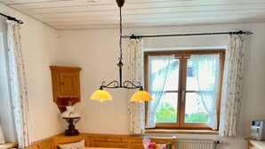 Un comedor acogedor con una mesa de madera, bancos y una ventana con cortinas.
