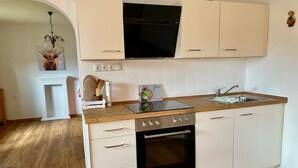 Una cocina compacta con horno empotrado, microondas y fregadero.
