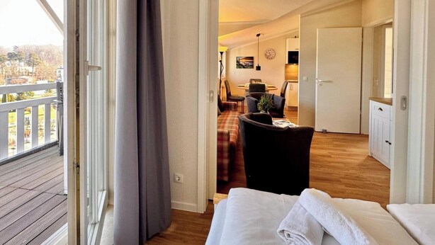 Ein Hotelzimmer mit Balkon, Essbereich und Küche.