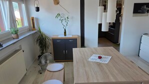 Eine moderne Küche mit einem Holztisch, zwei weißen Tellern, einem Ventilator und einer Topfpflanze.
