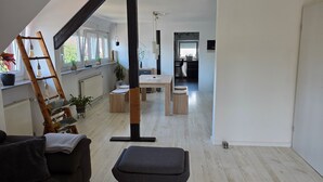 Ein modernes Wohnzimmer mit Schlafgalerie, Essbereich und Küche.