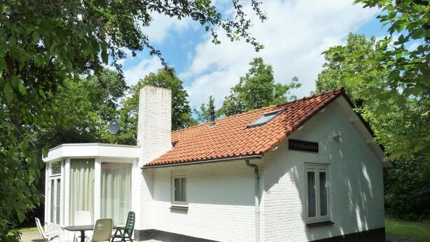 En liten vit byggnad med ett rött tegeltak, en skorsten och en skylt med texten ”J. M. VELASCO”.