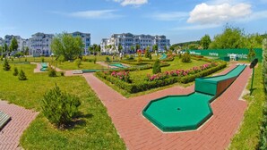 A landscaped area with a pool, pathways, and residential buildings in the background. - Komfortable Ferienwohnung für Zwei in Sellin mit Balkon (Sellin)