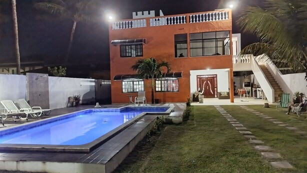 A two-story building with a swimming pool, outdoor seating, and a staircase leading to an upper level. - Premium retreat with private pool in Arembepe (Abrantes)