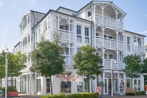 Un bâtiment blanc doté de nombreux balcons et d’une vitrine.