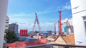 Una obra en construcción con varias grúas y edificios al fondo.