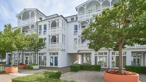 A multi-story building with balconies, a central courtyard, and potted plants. - Stilvolle Ferienwohnung mit Balkon in Sellin (Sellin)