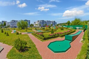 Ein angelegter Innenhof mit Pool, Wegen und einem Gebäude mit mehreren Balkonen.