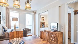 Ein Hotelzimmer mit einem Holztisch, Stühlen, einem Fernseher und einem Bett.