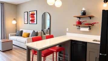 Una cocina moderna con comedor, sofá y obras de arte en la pared.