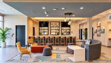 Een moderne lobby met een bar, zitplaatsen en kunstwerken aan de muren.