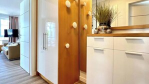 A modern kitchen with white cabinets, wooden accents, and a plant on the counter. - Holiday apartment with balcony and Ahoi discount (Sellin)