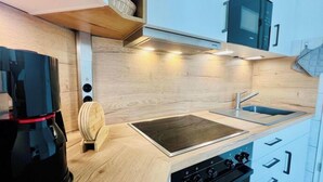 Een moderne keuken met een ingebouwde kookplaat, een spoelbak en een koffiezetapparaat.