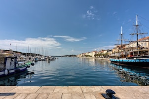 Un puerto con barcos, un muelle y edificios a lo largo de la costa.