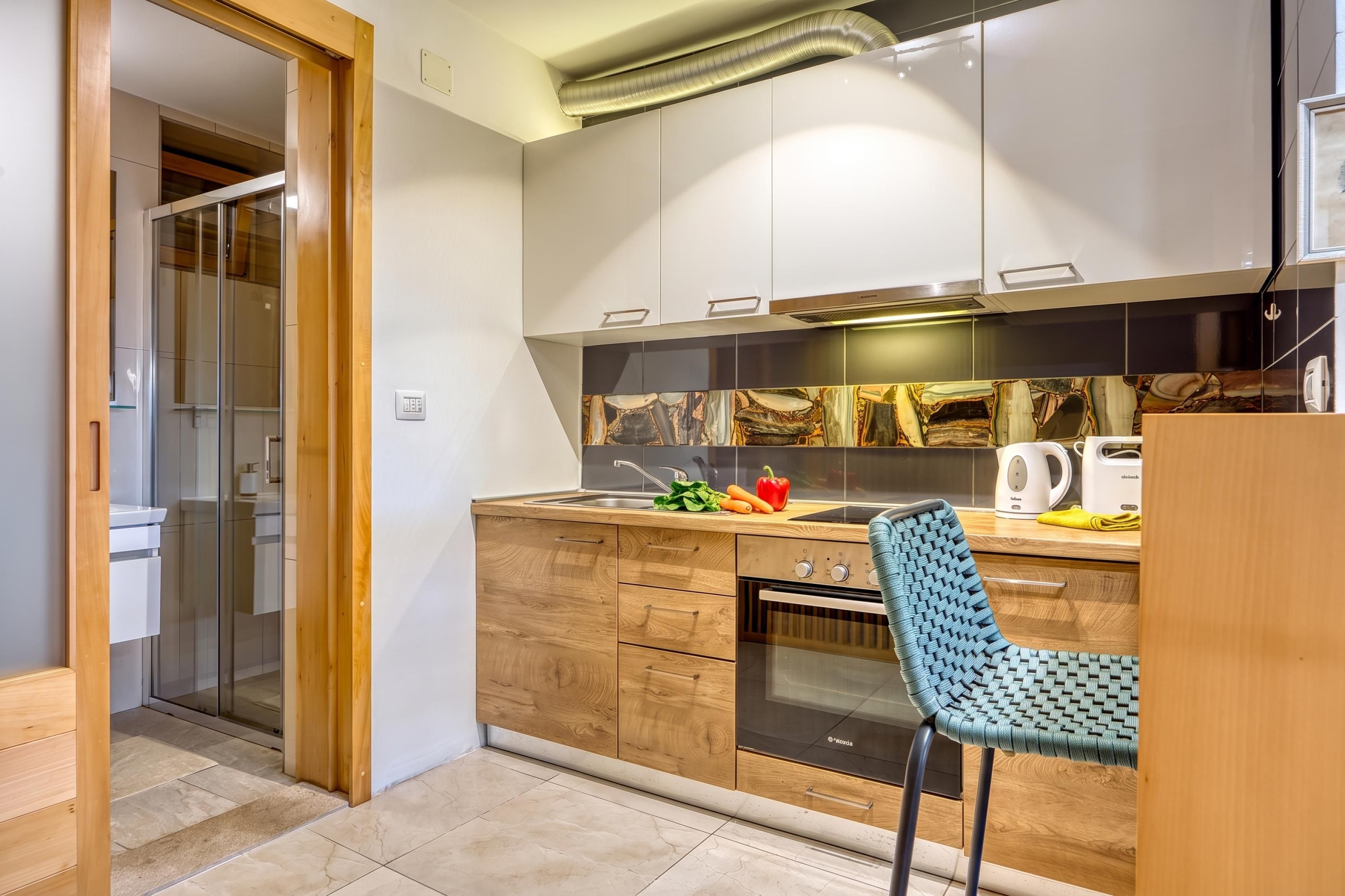 A modern kitchen with wooden cabinets, a built-in oven, and a sink.