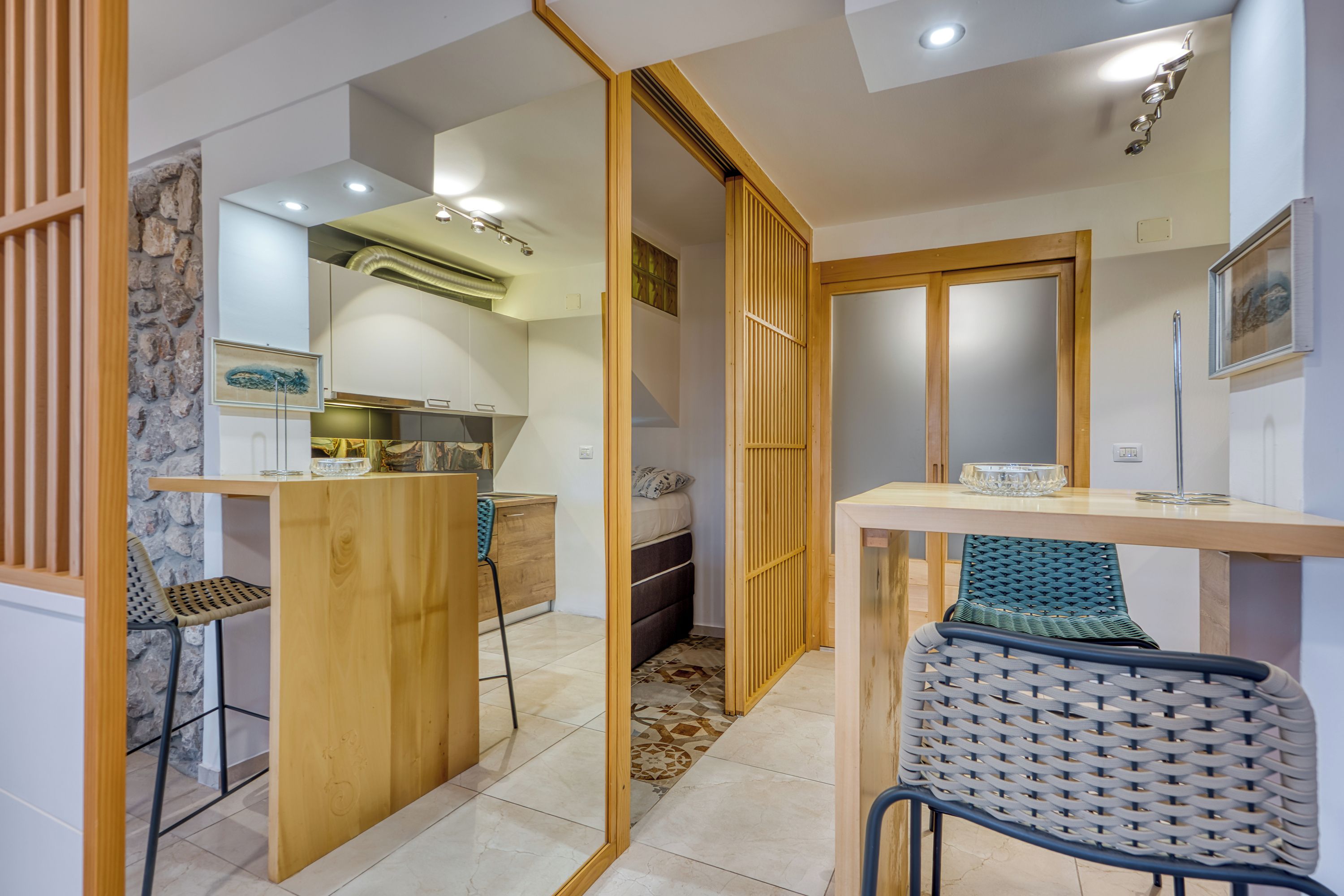 Un espace de vie compact comprenant un coin cuisine, un coin repas et une chambre.