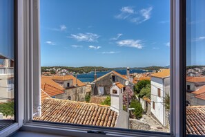 A coastal town with terracotta-roofed buildings, a clear blue sky, and a view of the sea. - 1BR Star Wars Inspired Duplex Loft /w Sea View (Mali Losinj)