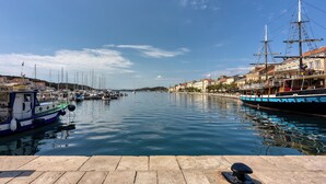 Un puerto con barcos, un muelle y edificios a lo largo de la costa.