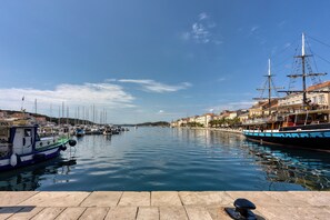 Un puerto con barcos, un muelle y edificios a lo largo de la costa.