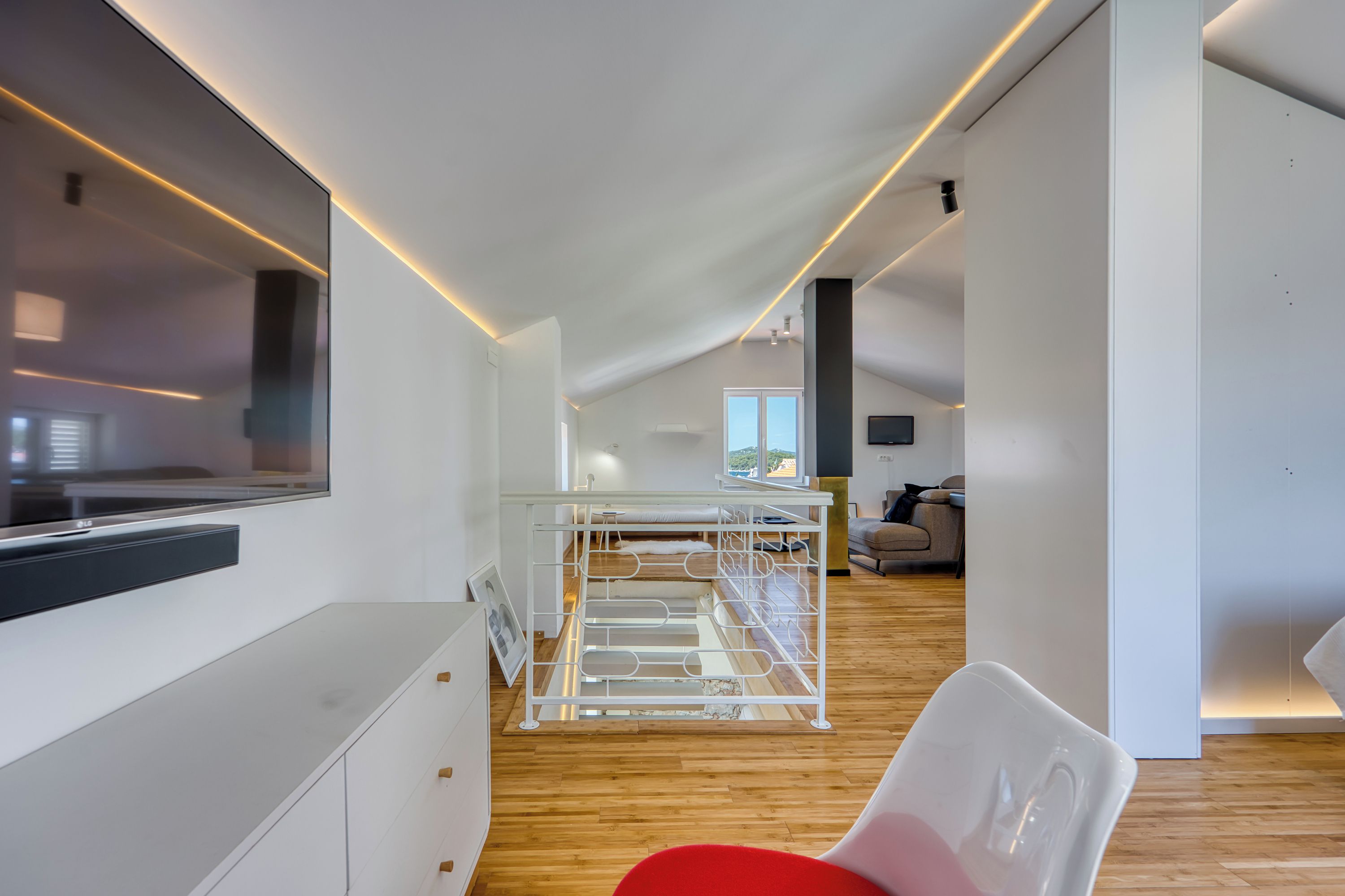 Ein modernes Interieur mit Etagenbett, Flachbildfernseher und Holzboden.