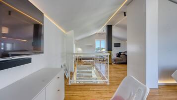 Ein modernes Interieur mit Etagenbett, Flachbildfernseher und Holzboden.