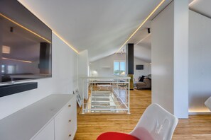 Ein modernes Interieur mit Etagenbett, Flachbildfernseher und Holzboden.