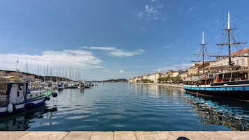 Ein Hafen mit Booten, einer Anlegestelle und Gebäuden entlang der Uferlinie.