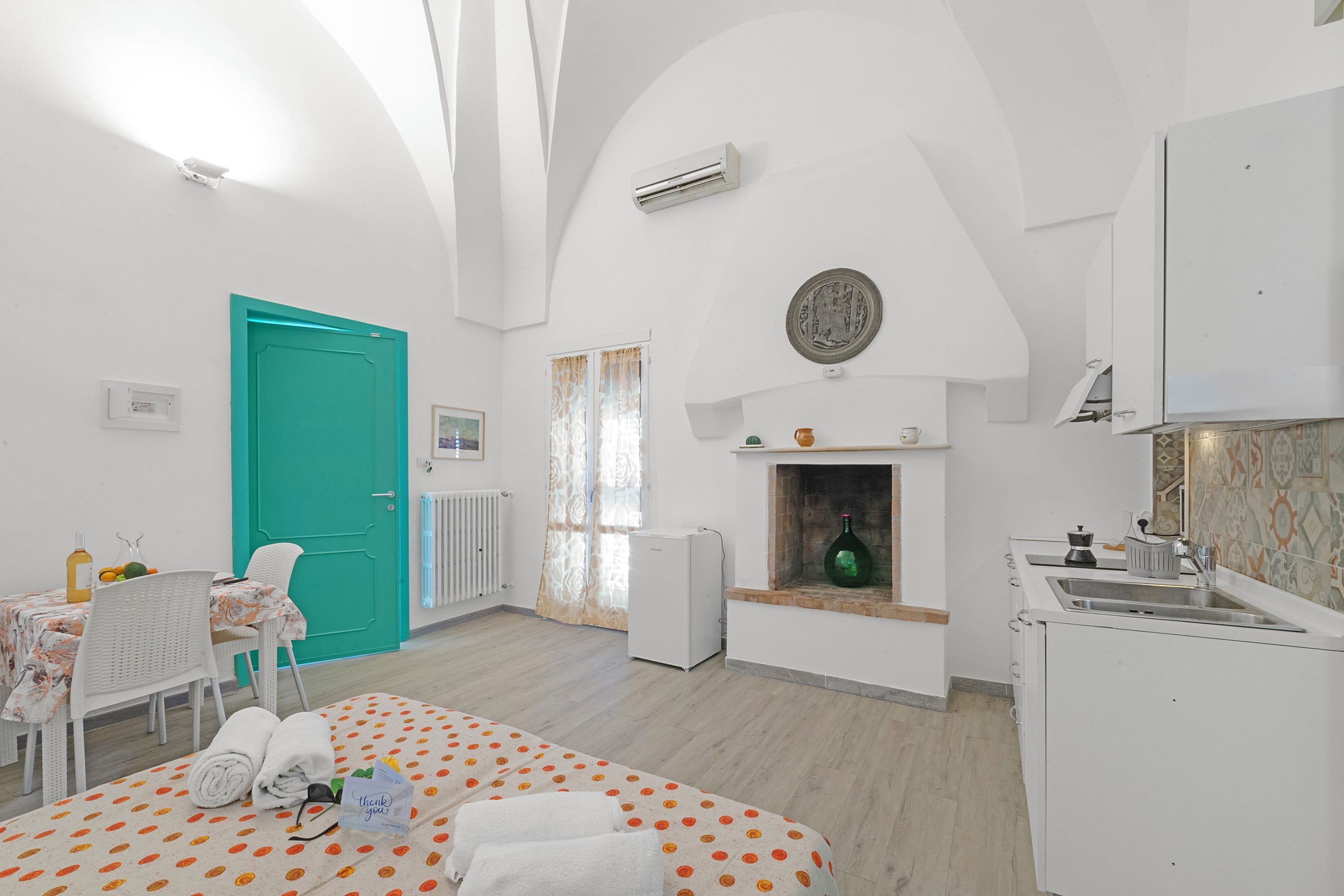 Una habitación con cama, mesa de comedor, zona de cocina y baño.