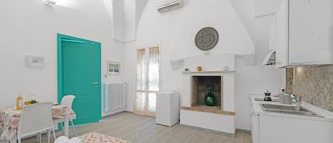 Una habitación con cama, mesa de comedor, zona de cocina y baño.