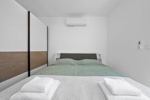 A modern hotel room with a bed, a wall-mounted air conditioner, and a bedside telephone. - Villa Ana Pool & Terrace (Vodice)