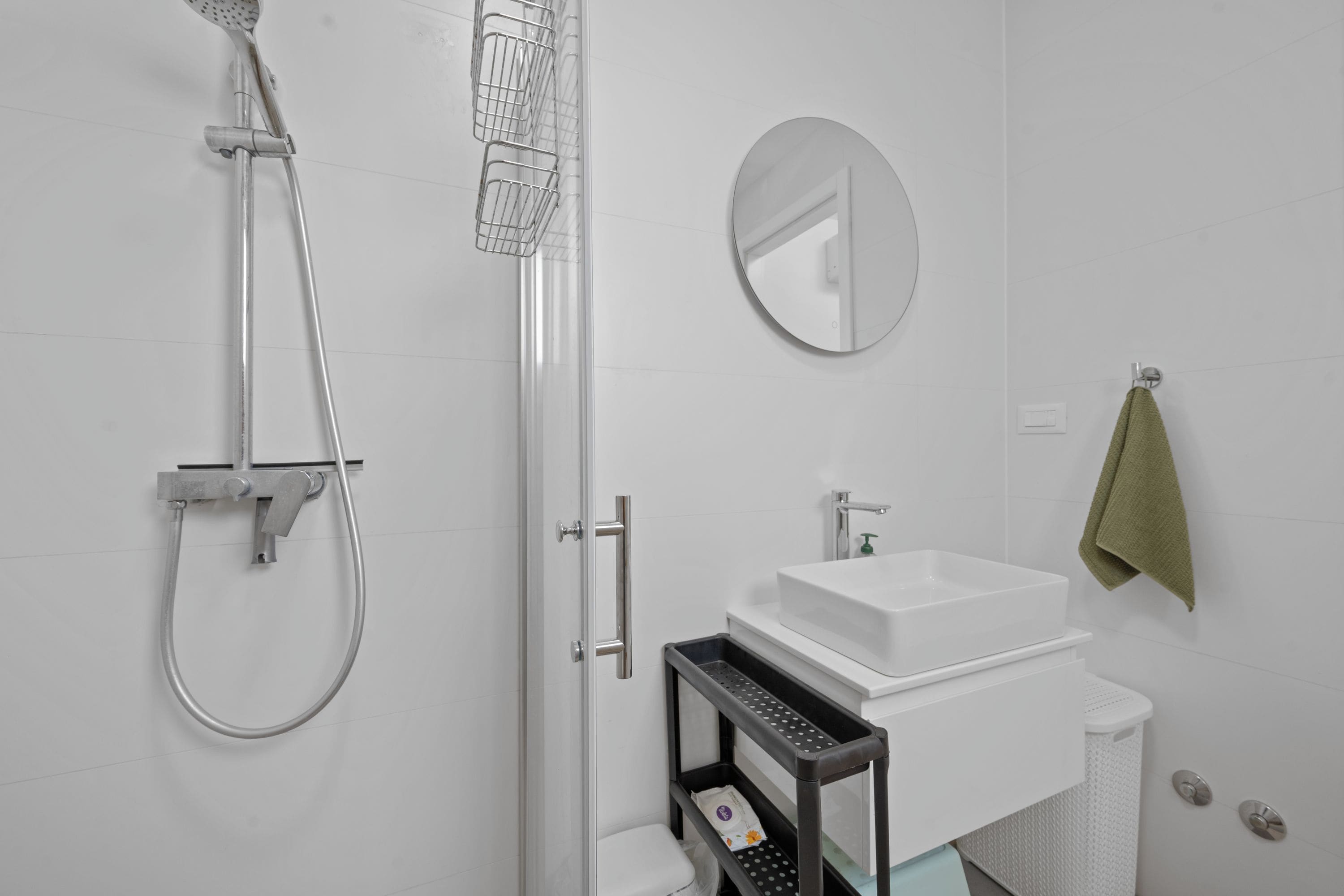 Une salle de bain moderne équipée d’une douche, de toilettes, d’un lavabo et d’un miroir.