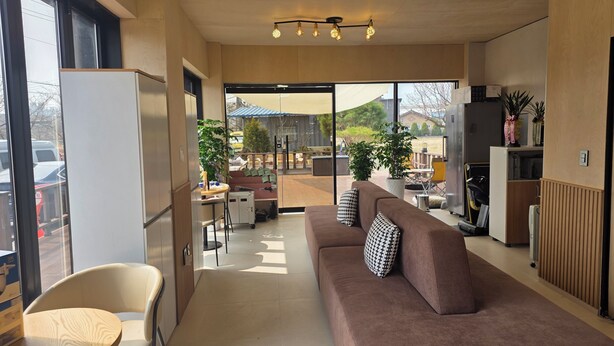 A modern interior with a sofa, a dining area, and a view of the outside.