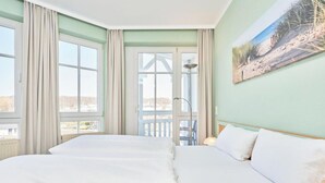 Ein Hotelzimmer mit einem großen Bett, einem Balkon mit Blick und einem Bild an der Wand.