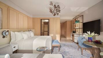 A hotel room with a bed, bedside table, chair, desk, and a television.