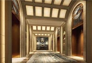 A grand hallway with a marble floor, a central chandelier, and a large window with a clock. - The Theodore Hanoi (Hanoi)