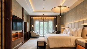 A modern hotel room with a large bed, a flat-screen TV, a chandelier, and a view of the outdoors. - The Theodore Hanoi (Hanoi)