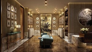 A luxurious spa area with a massage chair, wooden paneling, framed artwork, and a large mural. - The Theodore Hanoi (Hanoi)